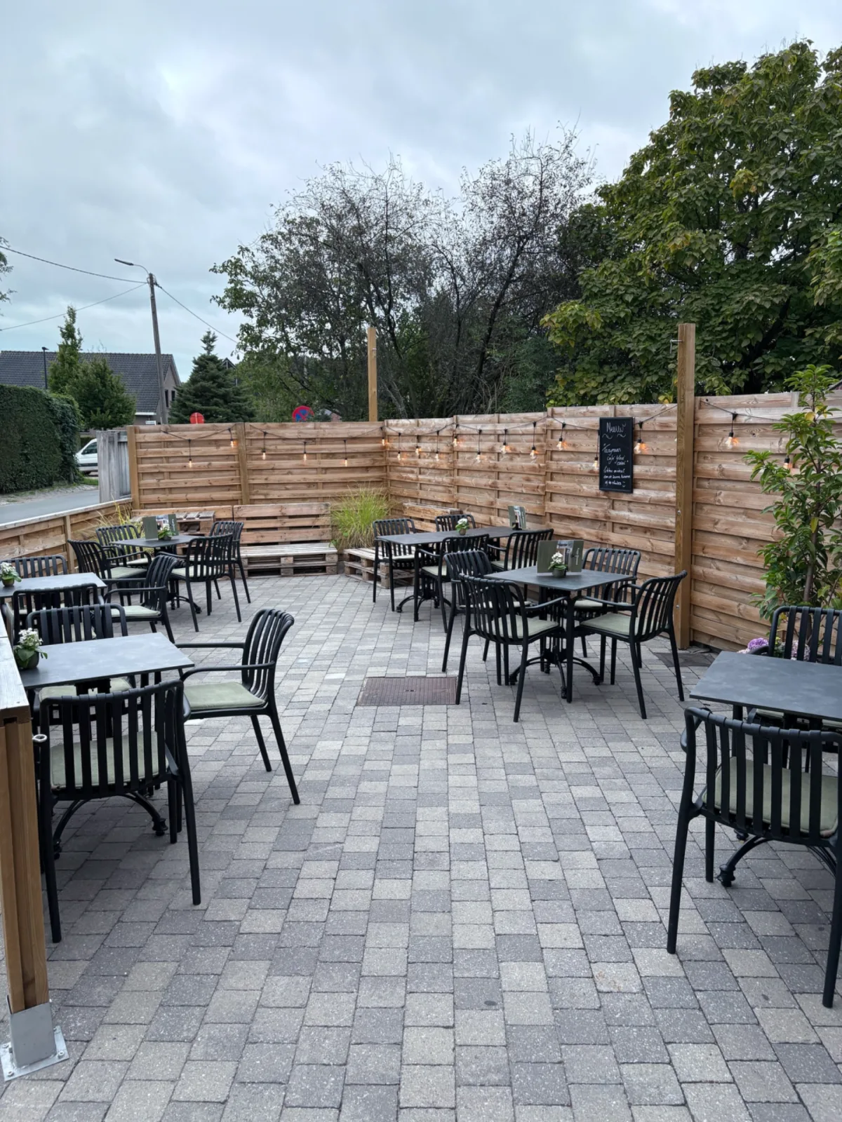 Het terras met lichtjes boven de tafels